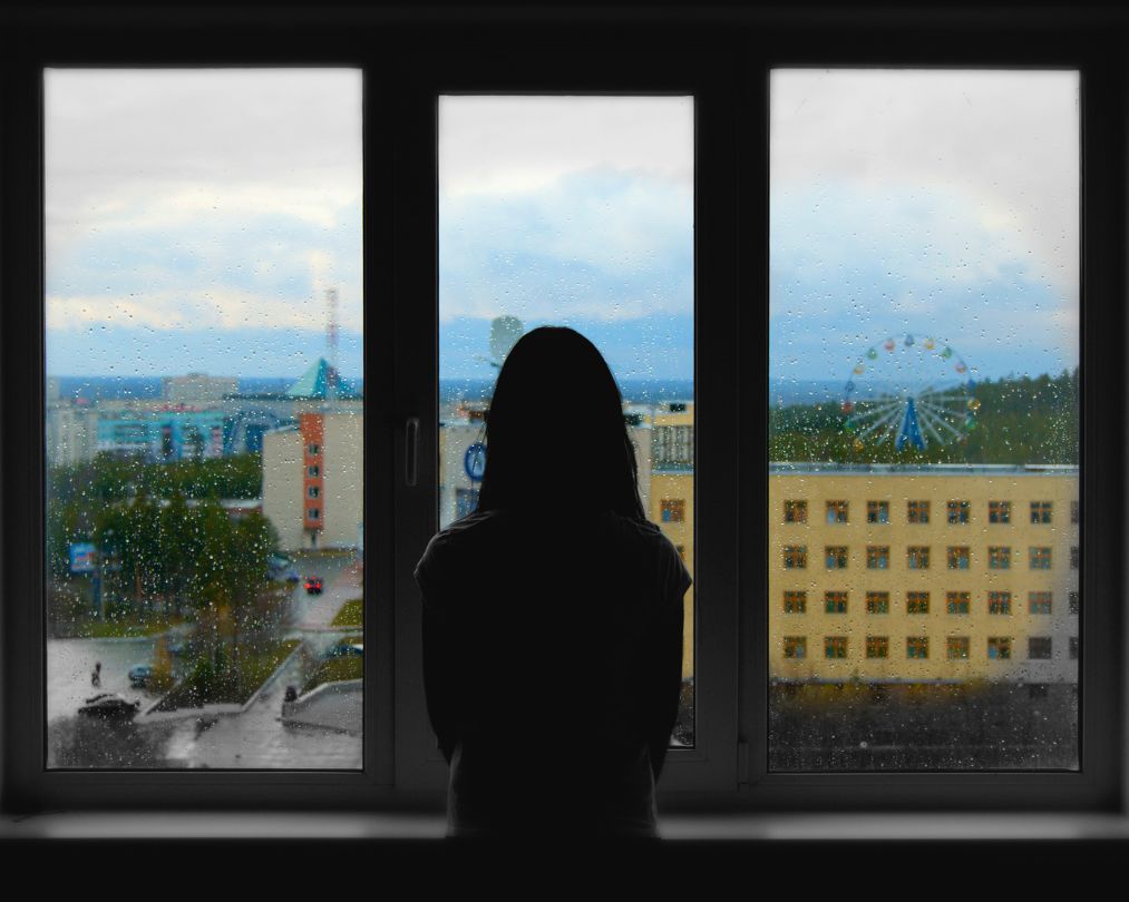 vrouw kijkt uit het raam