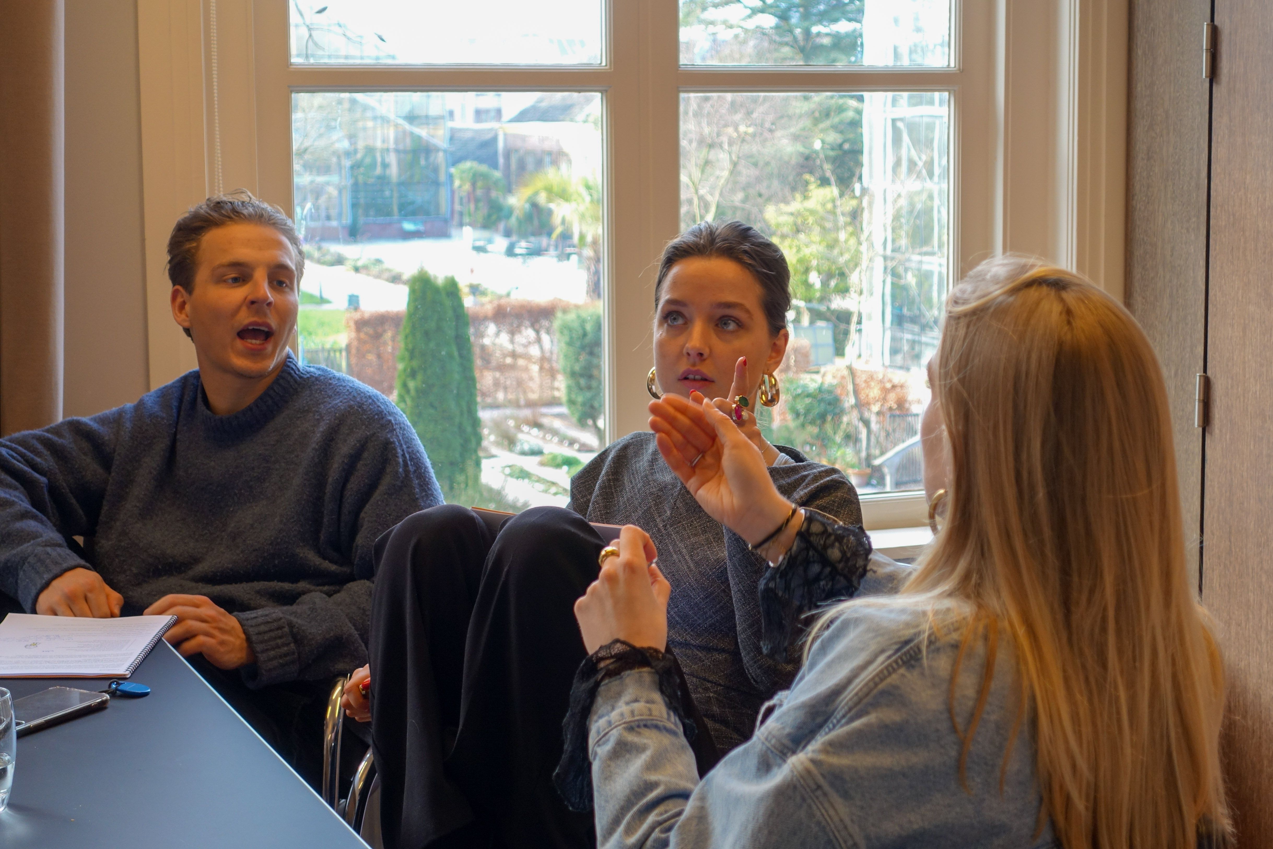3 mensen in gesprek vol handgebaren